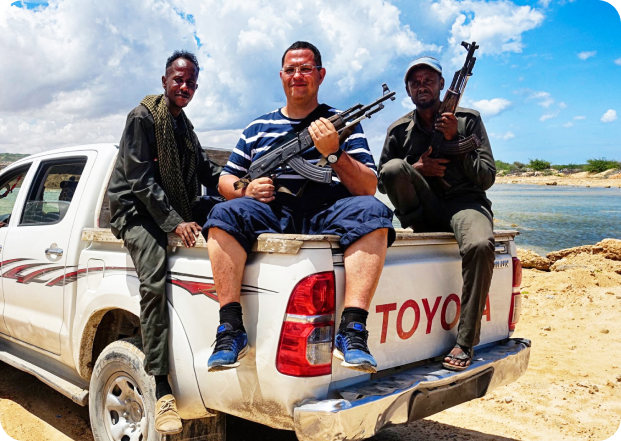 Костянтин з автоматом сидить на багажнику пікапа toyota