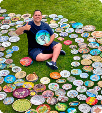 Костянтин на фоні багатьох розфарбованих тарілок