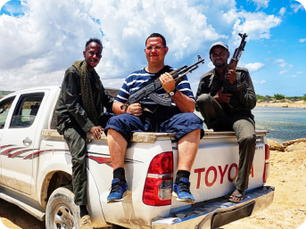 Костянтин з автоматом сидить на багажнику пікапа toyota